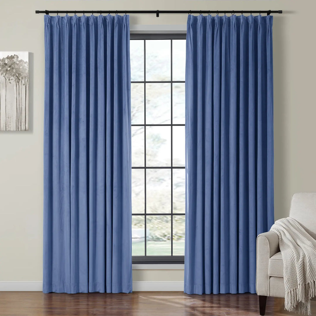 Light blue velvet curtains framing a large window in a cozy living room.