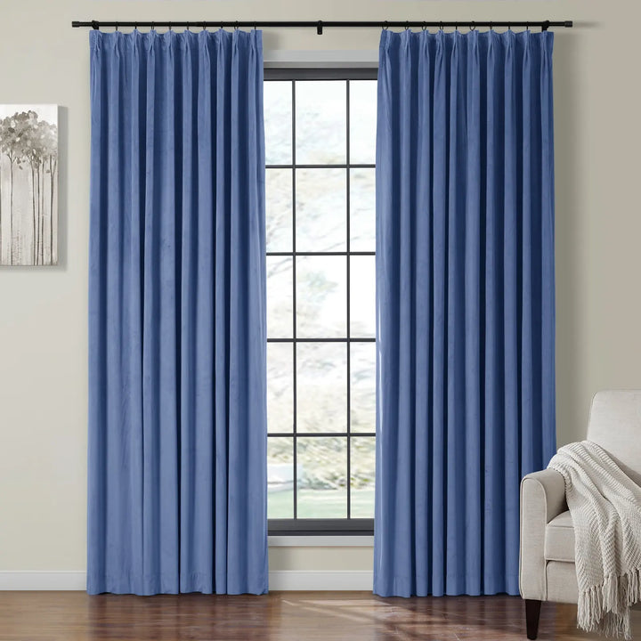 Light blue velvet curtains framing a large window in a cozy living room.