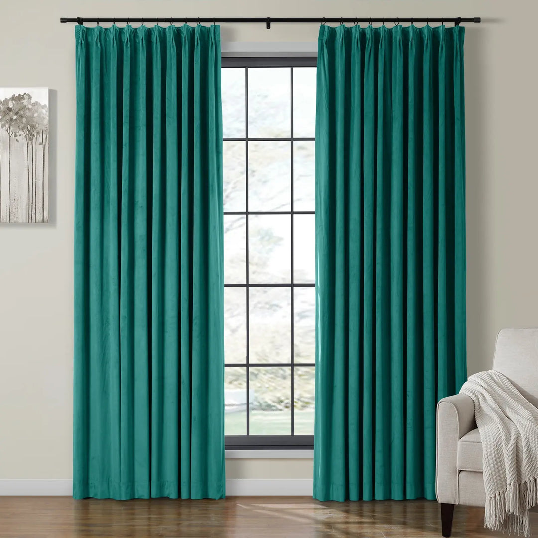 Turquoise velvet curtains framing a bright window in a stylish living room.