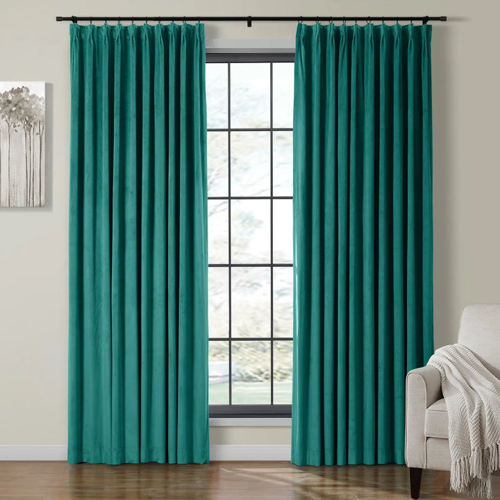 Turquoise velvet curtains framing a bright window in a stylish living room.