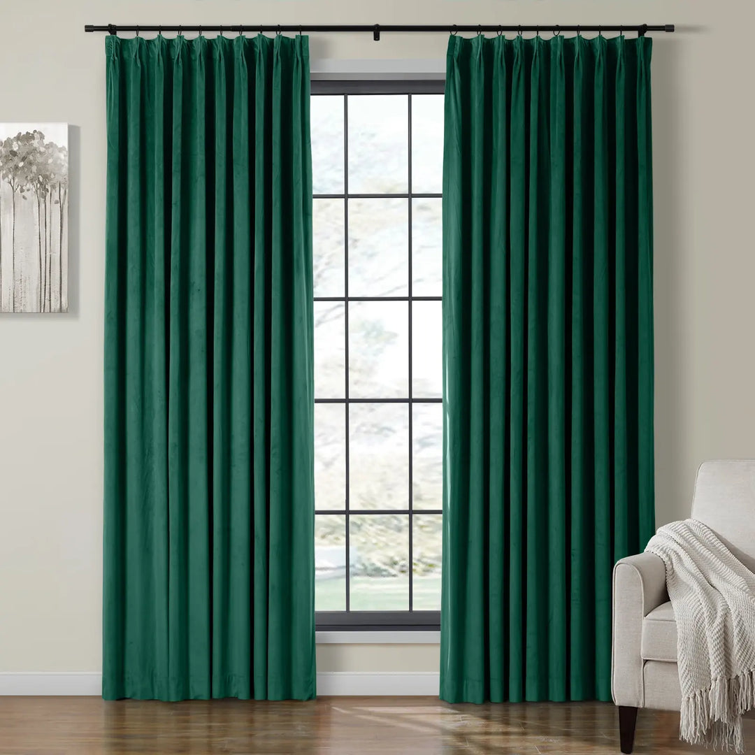 Dark green velvet curtains framing a bright window in a cozy living room