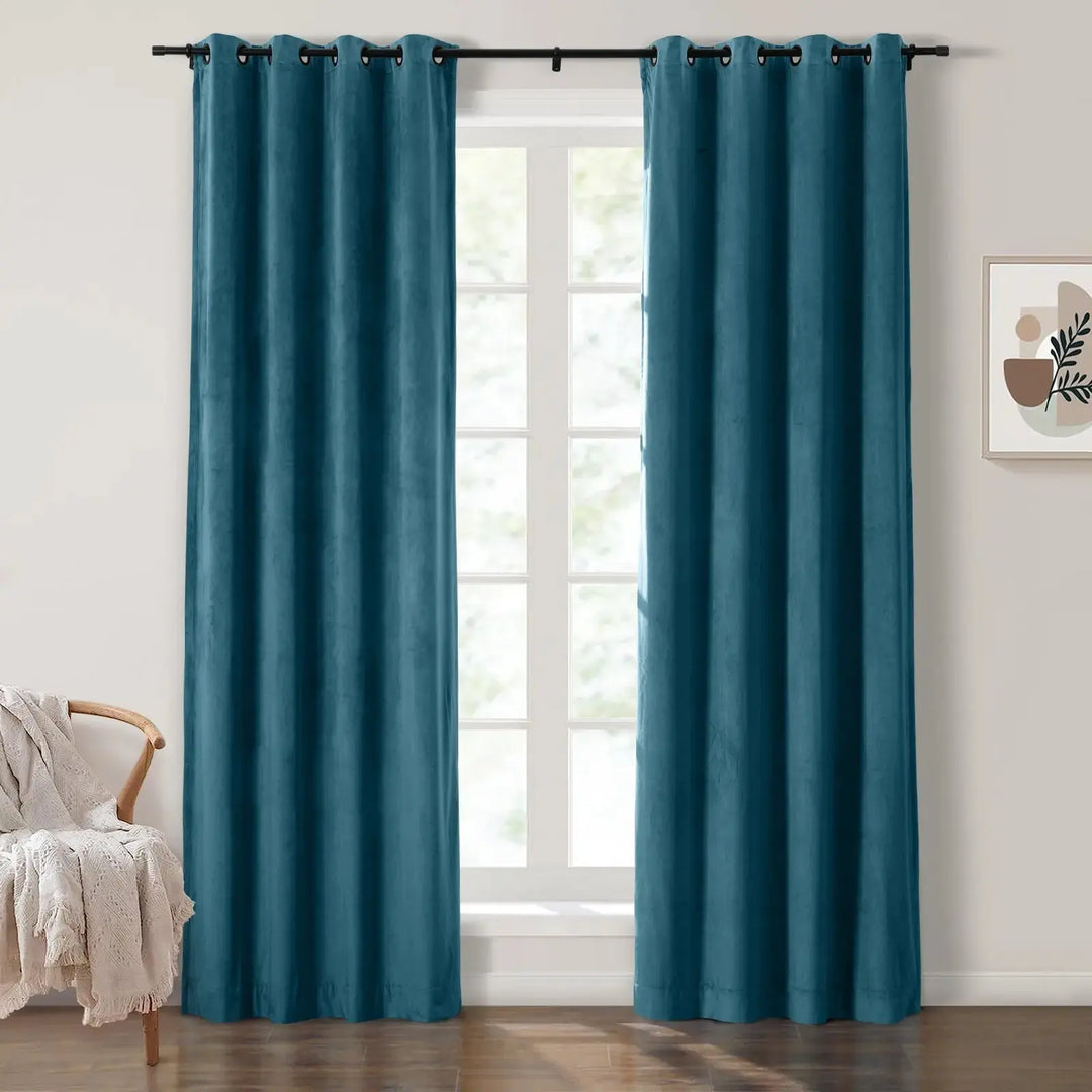 Teal velvet grommet curtains elegantly framing bright windows in a cozy living room.