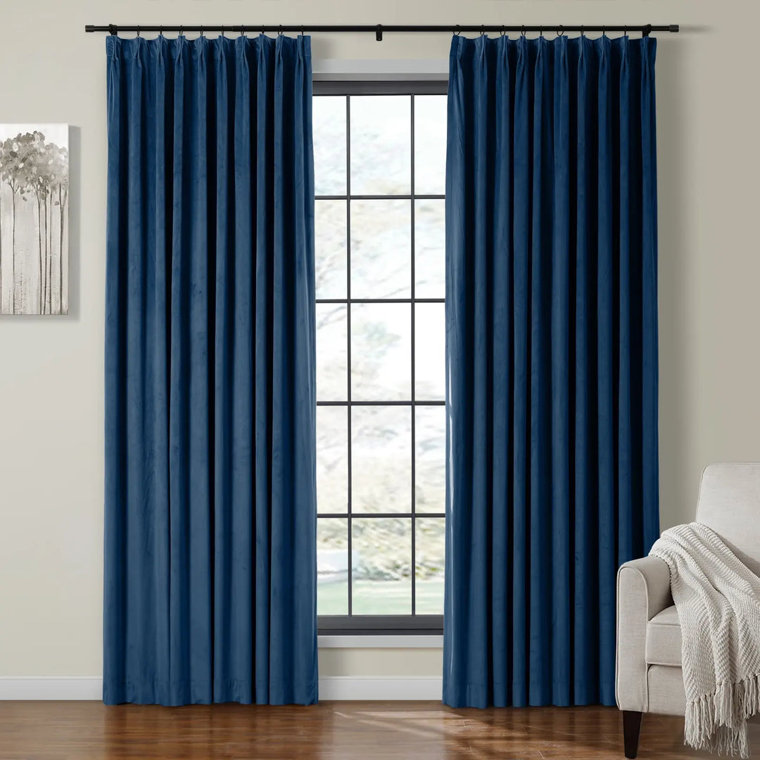 Dark blue velvet curtains draping beside a large window in a cozy living room.