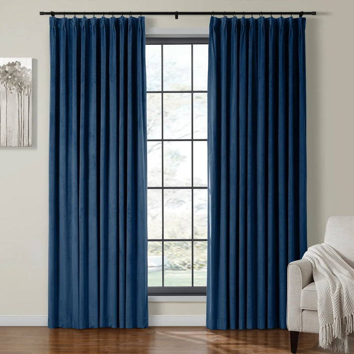 Dark blue velvet curtains draping beside a large window in a cozy living room.