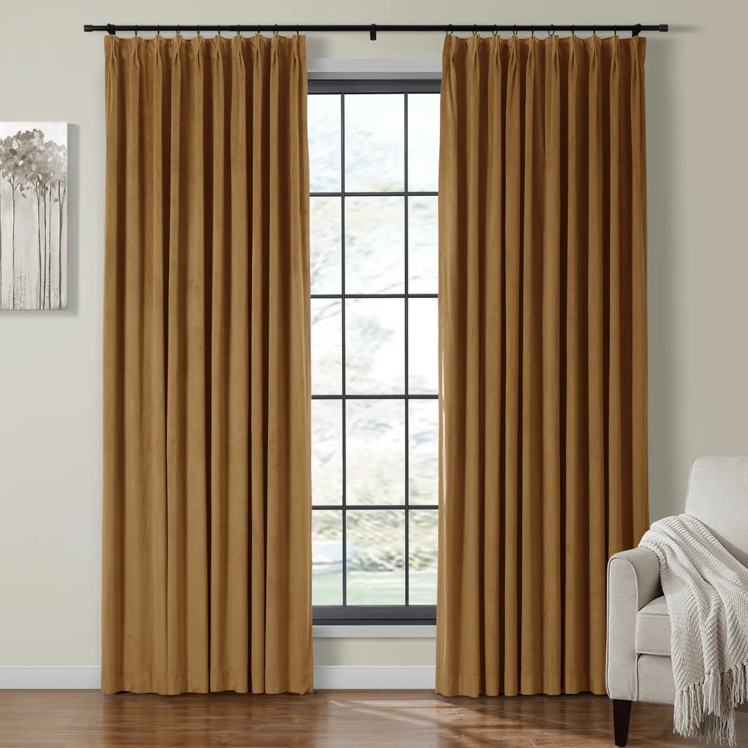 Pleated gold velvet curtains framing a large window in a cozy living room.