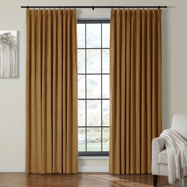 Pleated gold velvet curtains framing a large window in a cozy living room.