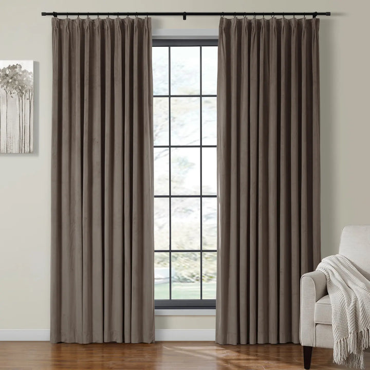 Taupe velvet curtains on black rod beside large window for elegant home decor.