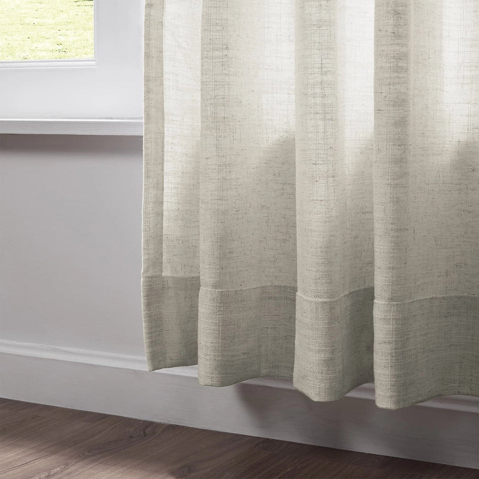 Close-up of pleated beige linen curtains showcasing texture and elegant draping