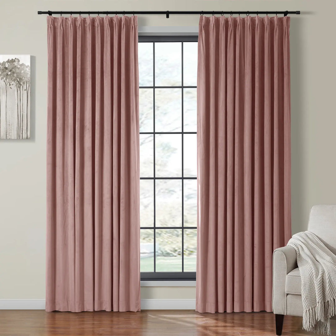 Pleated pink velvet curtains hanging beside a large window in a cozy living room.