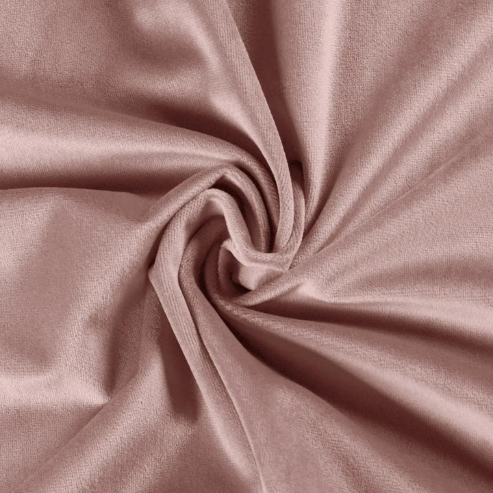 Close-up of soft blush velvet fabric showcasing smooth texture and elegant draping.