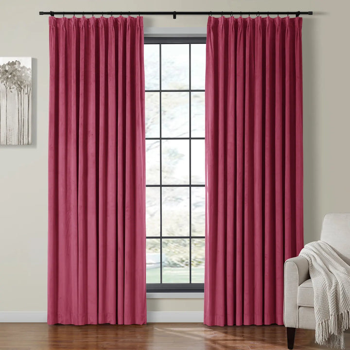 Elegant pink velvet curtains draping beside a bright window in a cozy living room.