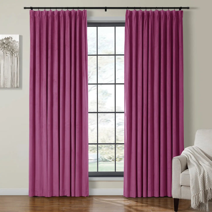 Pleated pink velvet curtains beside a large window in a cozy living room.
