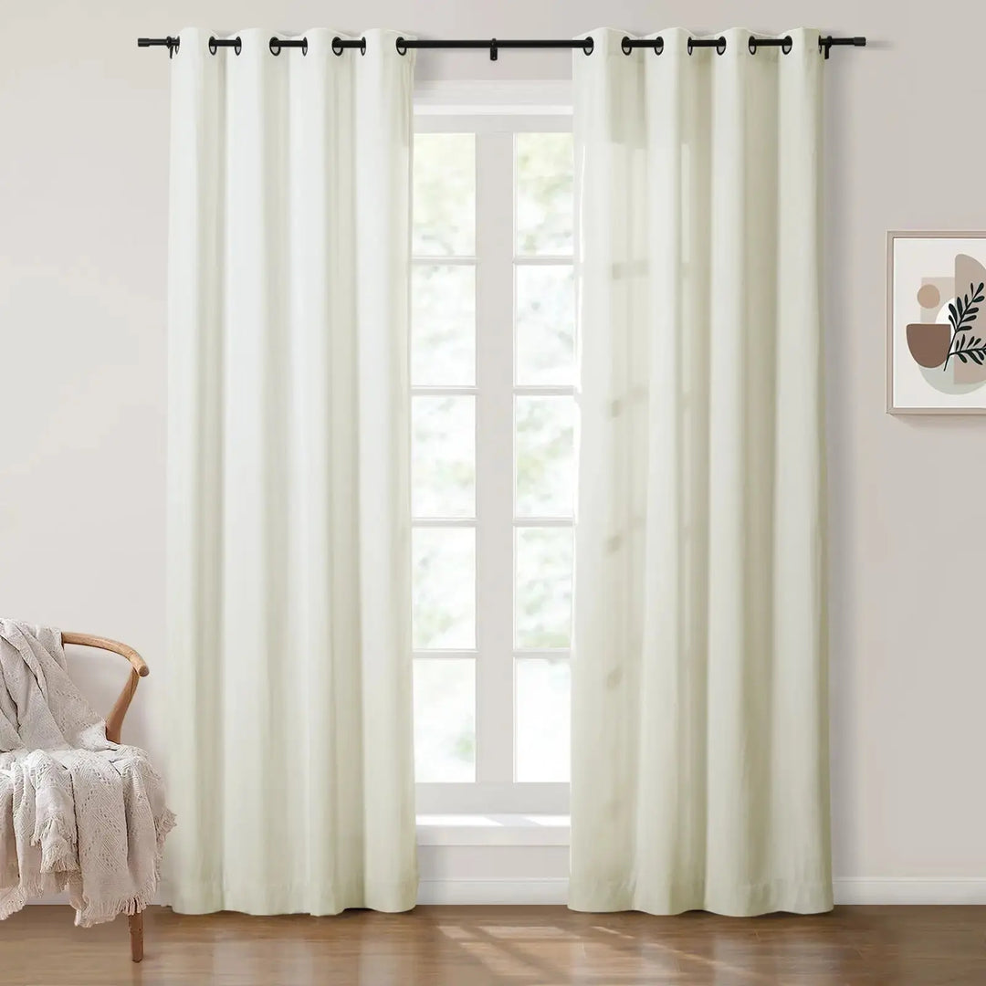Light beige grommet curtains framing large windows in a bright room.