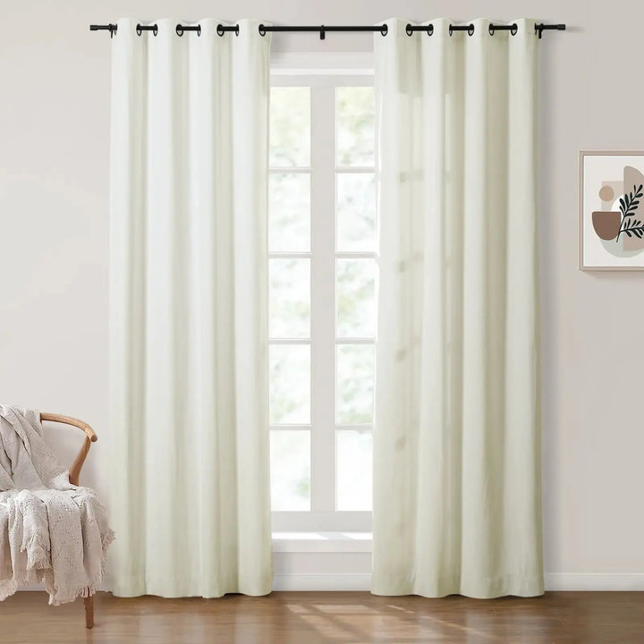 Light beige grommet curtains framing large windows in a bright room.