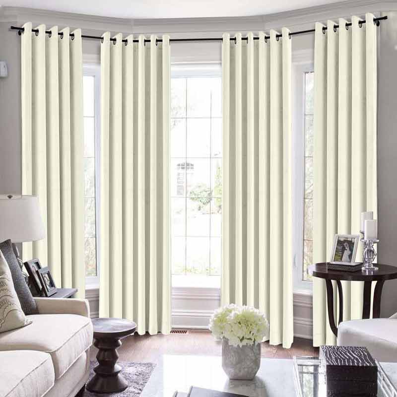 Bright living room with white grommet curtains framing large windows and stylish decor.