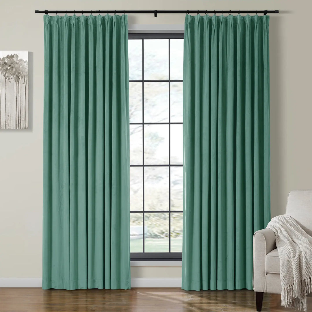 Teal pleated velvet curtains framing a bright window in a cozy living room.