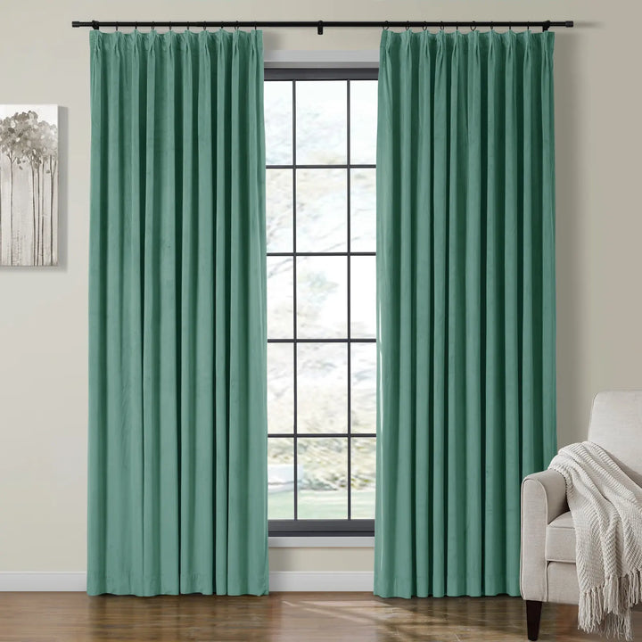 Teal pleated velvet curtains framing a bright window in a cozy living room.