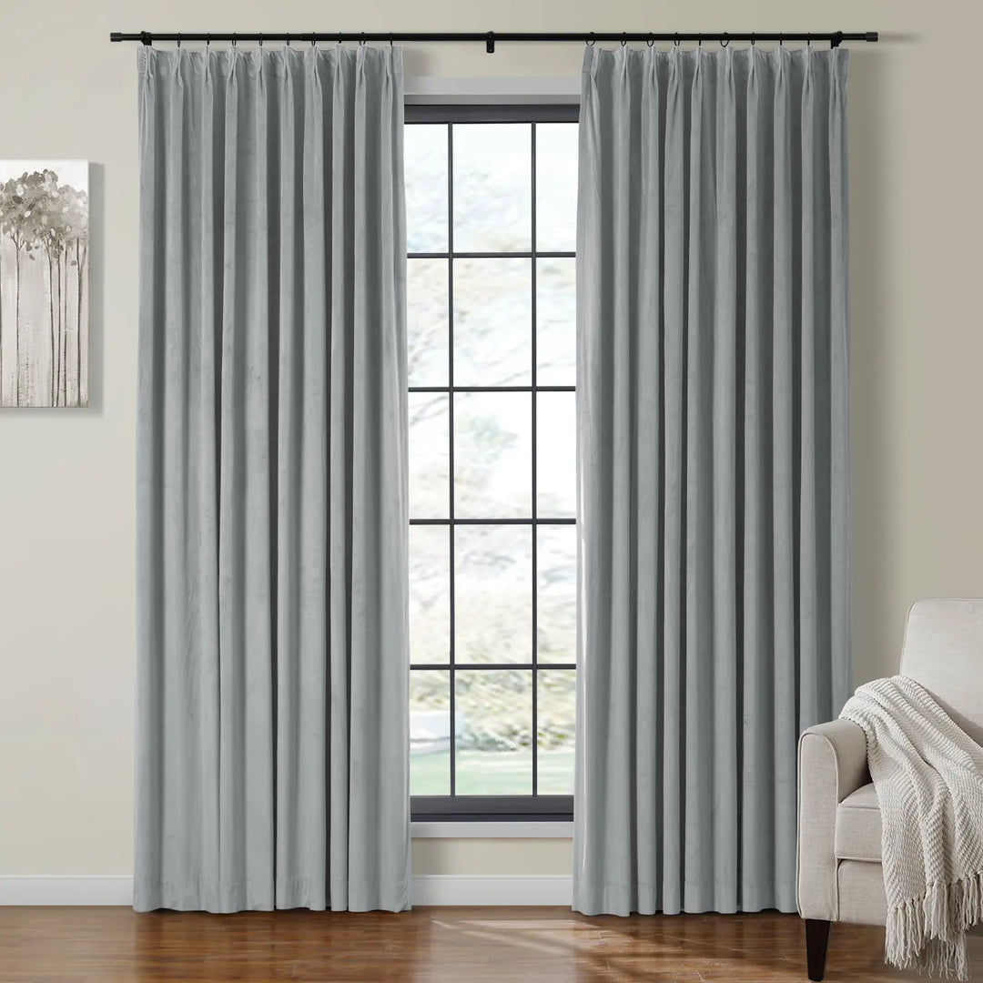 Light blue velvet curtains elegantly draped by a large window in a cozy living space.