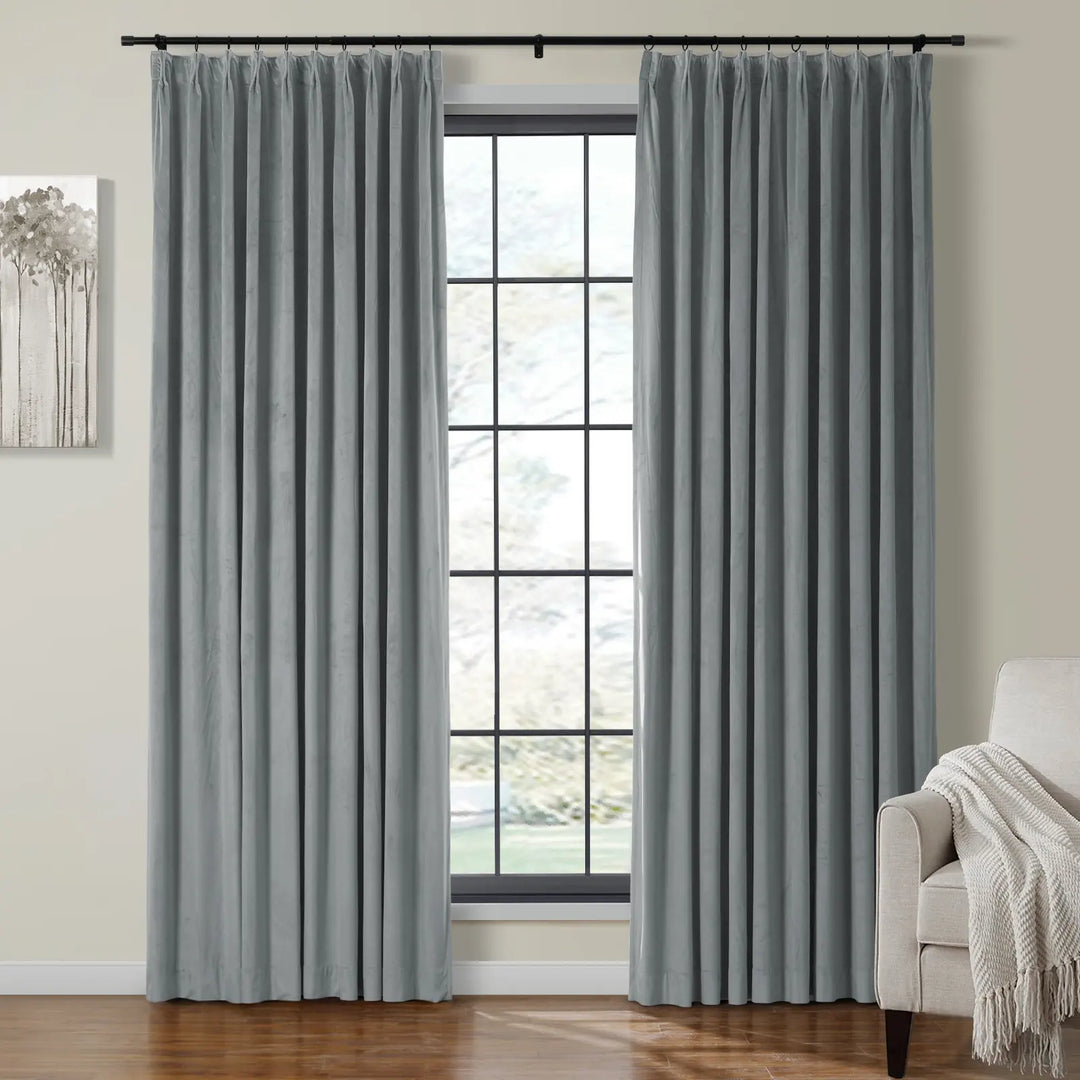 Light grey velvet curtains draping beside a large window in a cozy living room.