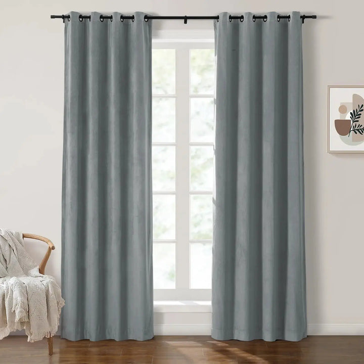Soft gray velvet grommet curtains framing large windows in a bright, airy room.