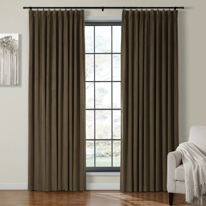 Dark taupe velvet curtains draped beside large window with beige sofa in cozy living room.