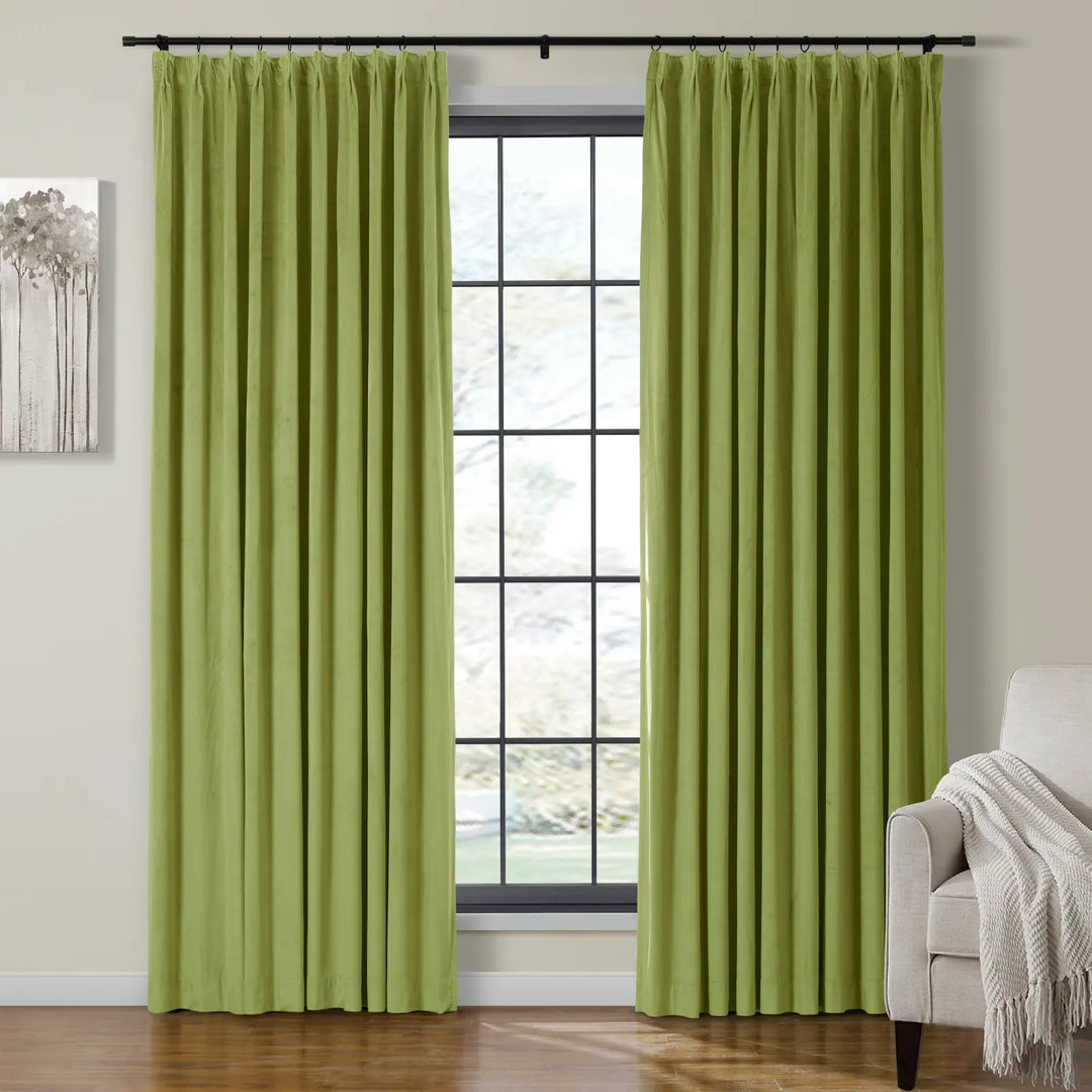 Light green velvet pleated curtains beside a large window in a cozy living room.