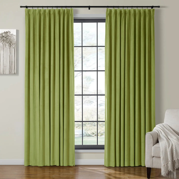 Light green velvet pleated curtains beside a large window in a cozy living room.