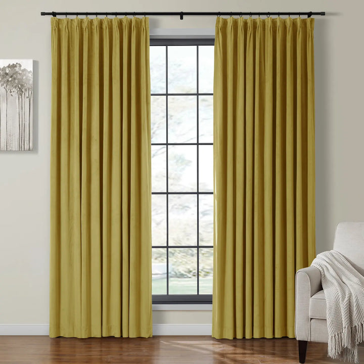 Mustard yellow pleated velvet curtains framing a large window in a cozy living room.